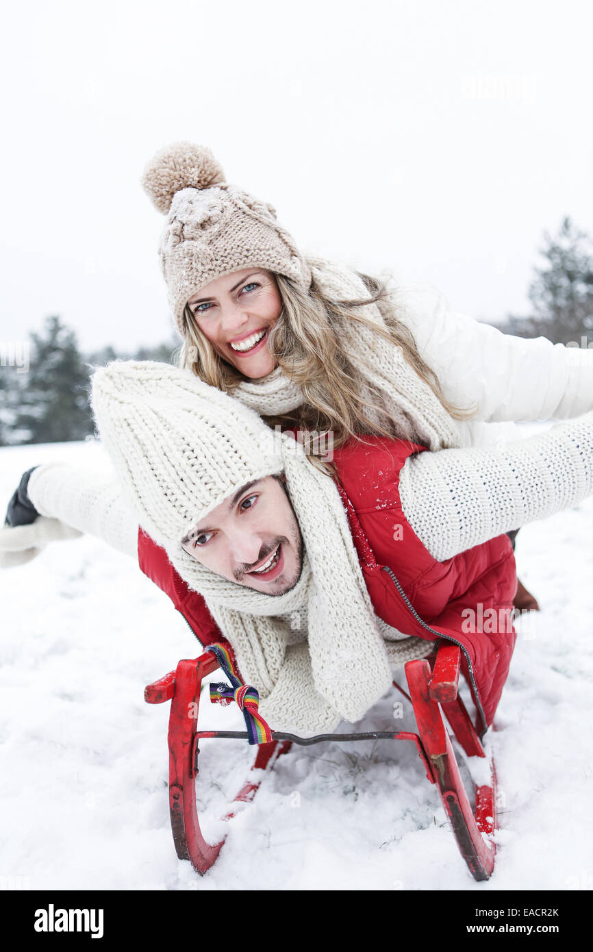 Glückliches Paar auf einem Schlitten im Winter im Schnee Stockfoto