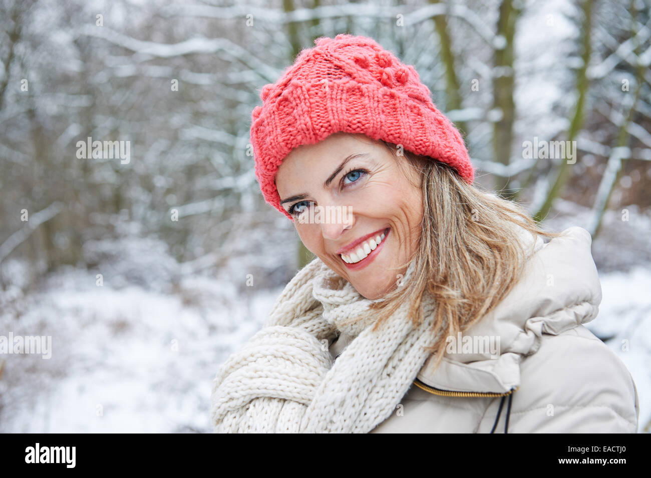 Glückliche Frau Wandern im Winterwald mit Schnee Stockfoto