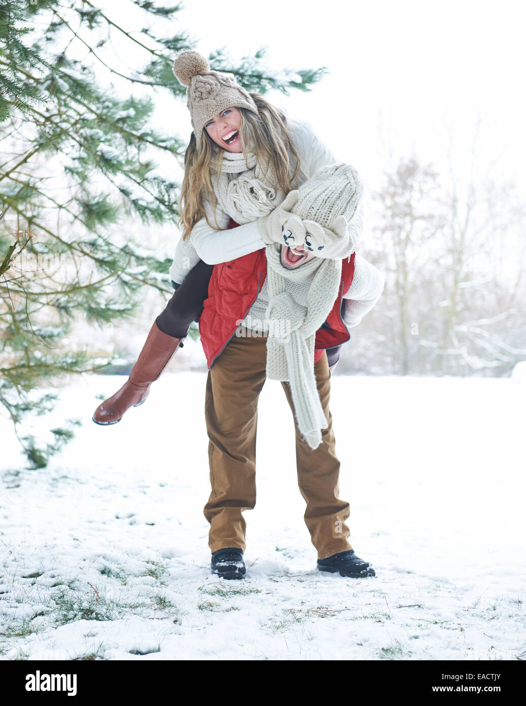 Glückliche Paare, die Spaß im Winter bei einem Spaziergang durch den Schnee Stockfoto