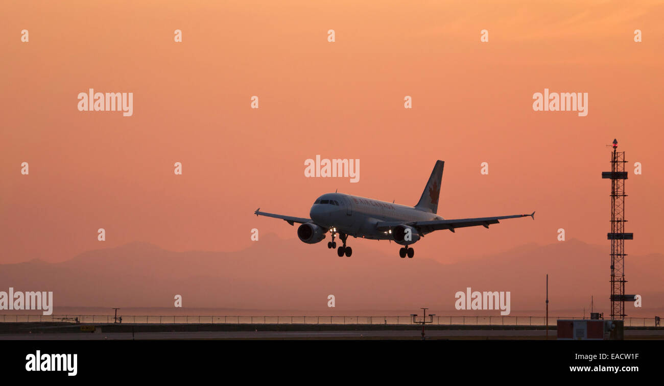 Silhouette Air Canada Airbus A319 Jetliner landet auf dem internationalen Flughafen Vancouver farbenfrohen Sonnenuntergang Dämmerung Stockfoto