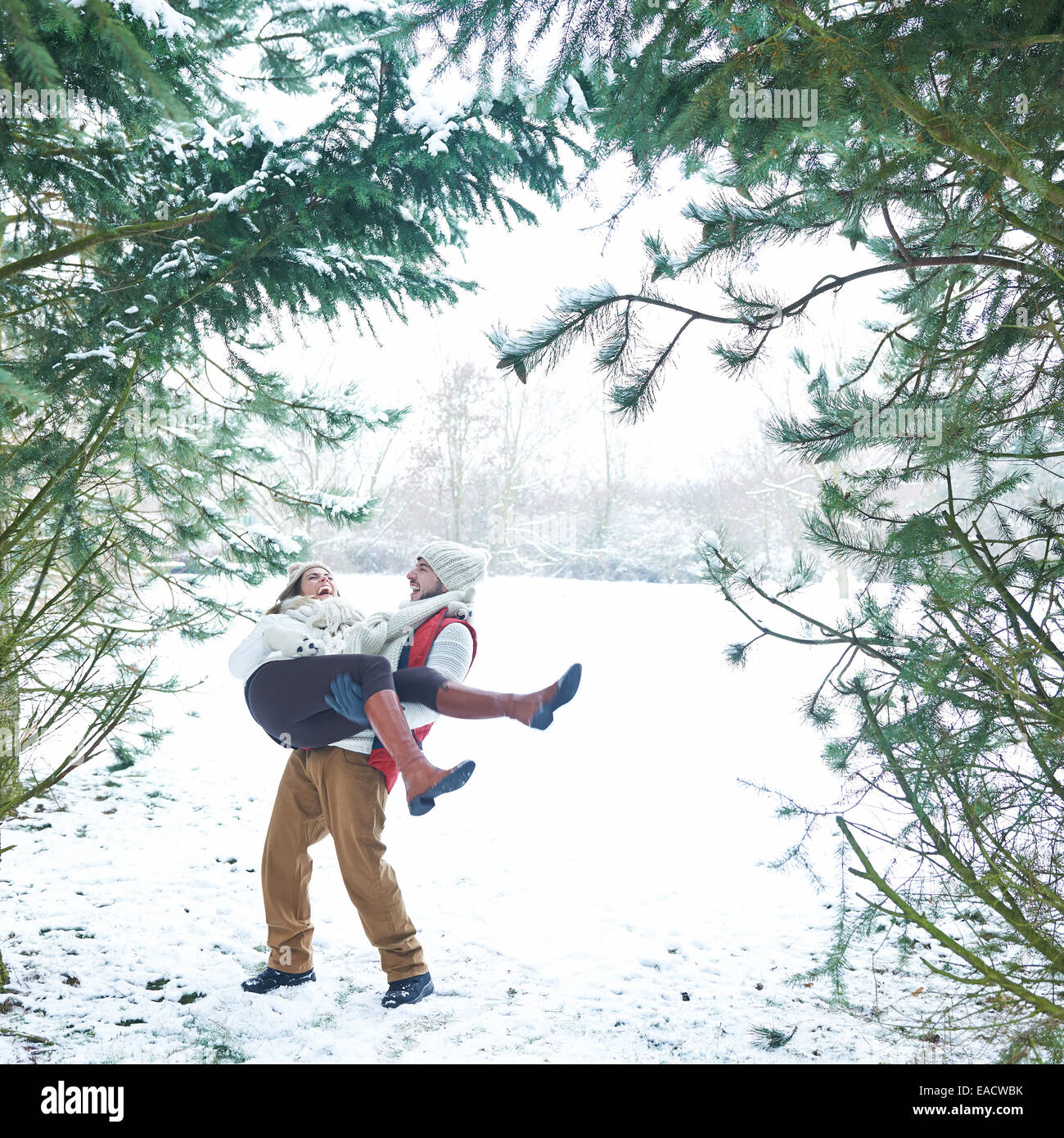 Paare, die Spaß im Schnee im Winterwald Stockfoto