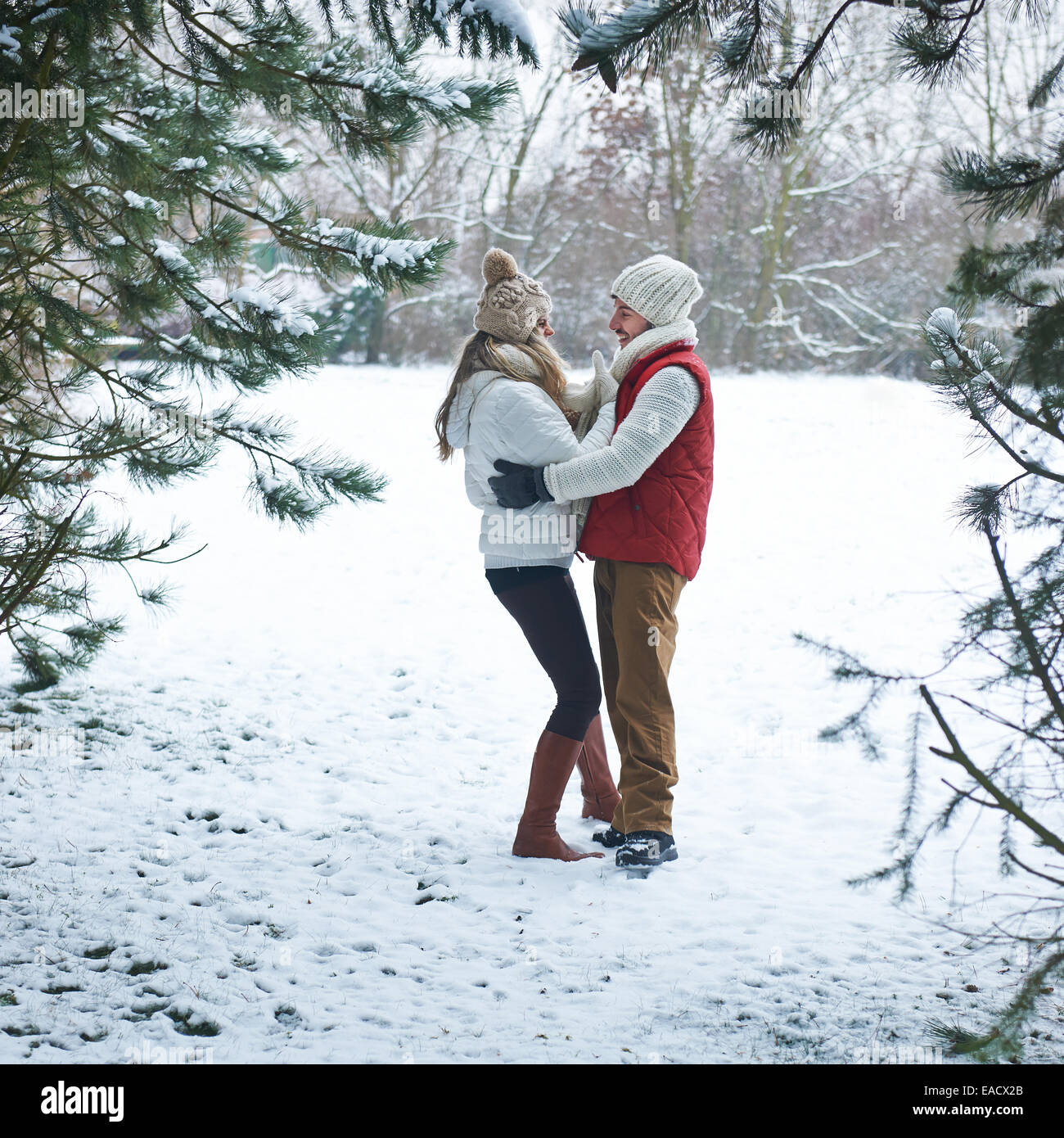 Brautpaar stehend im Winterwald mit Schnee Stockfoto