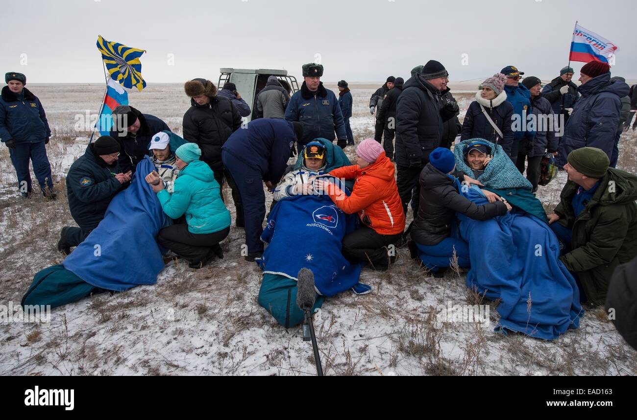 ISS-Expedition 41 Mannschaft Alexander Gerst von der European Space Agency, links, Kommandant Max Suraev der russischen Federal Space Agency, Zentrum und NASA-Astronaut Reid Wiseman, sitzen auf Stühlen vor der Sojus TMA - 13M Kapsel nur wenige Minuten nach der Landung in einer abgelegenen Gegend 10. November 2014 in der Nähe von Arkalyk Kasachstan. Surajew, Wiseman und Gerst Rückkehr zur Erde nach mehr als fünf Monate an Bord der internationalen Raumstation ISS, wo sie als Mitglieder der Expedition 40 und 41 Mannschaften dienten. Stockfoto