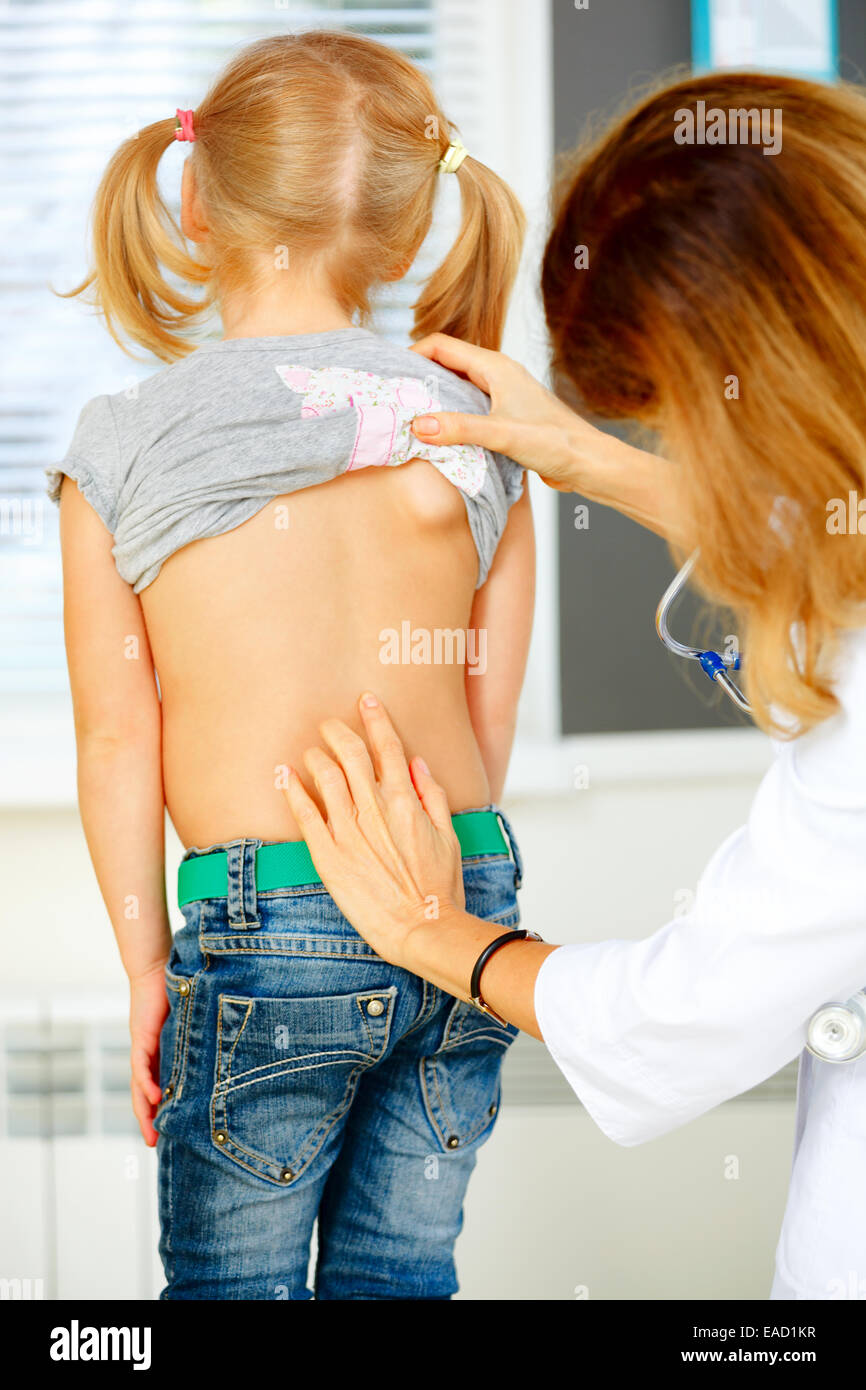 Kinderarzt Prüfung kleines Mädchen mit Rückenproblemen. Stockfoto