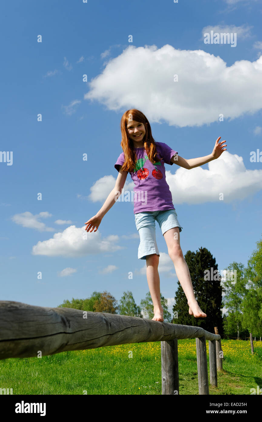 Mädchen, 11 Jahre, balancieren auf einem hölzernen Geländer bin Uffing Staffelsee, Pfaffenwinkel Region, Upper Bavaria, Bavaria, Germany Stockfoto