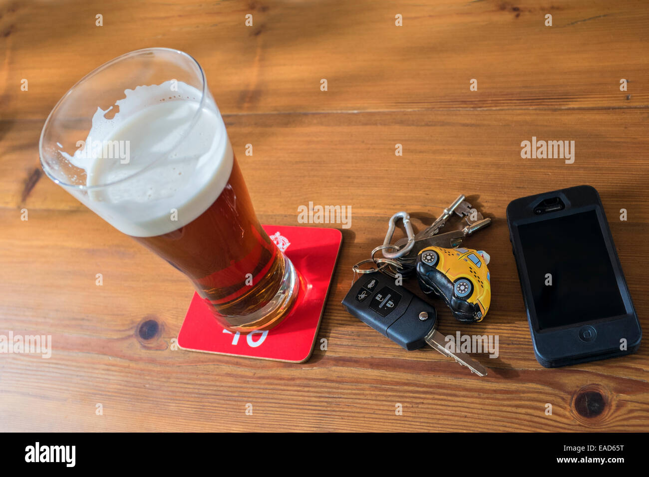 Autoschlüssel, Pint Bier und ein Mobiltelefon. Stockfoto