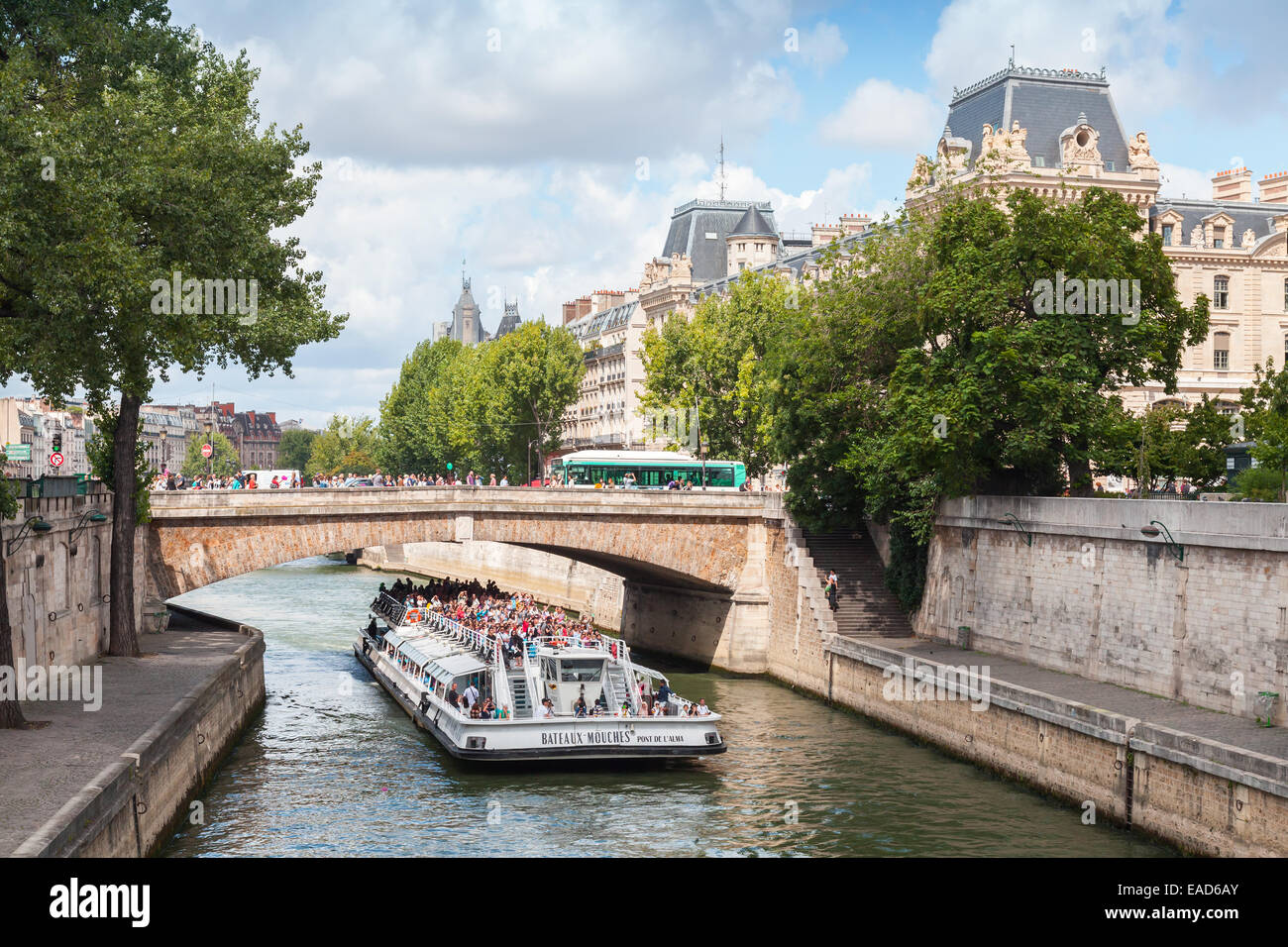 Paris, Frankreich - 11. August 2014: Weiße touristische Passagierschiff von Bateaux-Mouches betrieben geht unter der Brücke am Seineufer Stockfoto