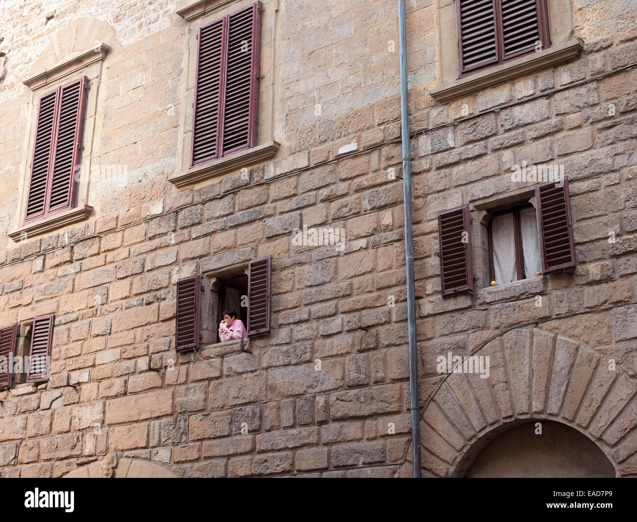 Person im Fenster zu Hause in Florenz, Italien Stockfoto