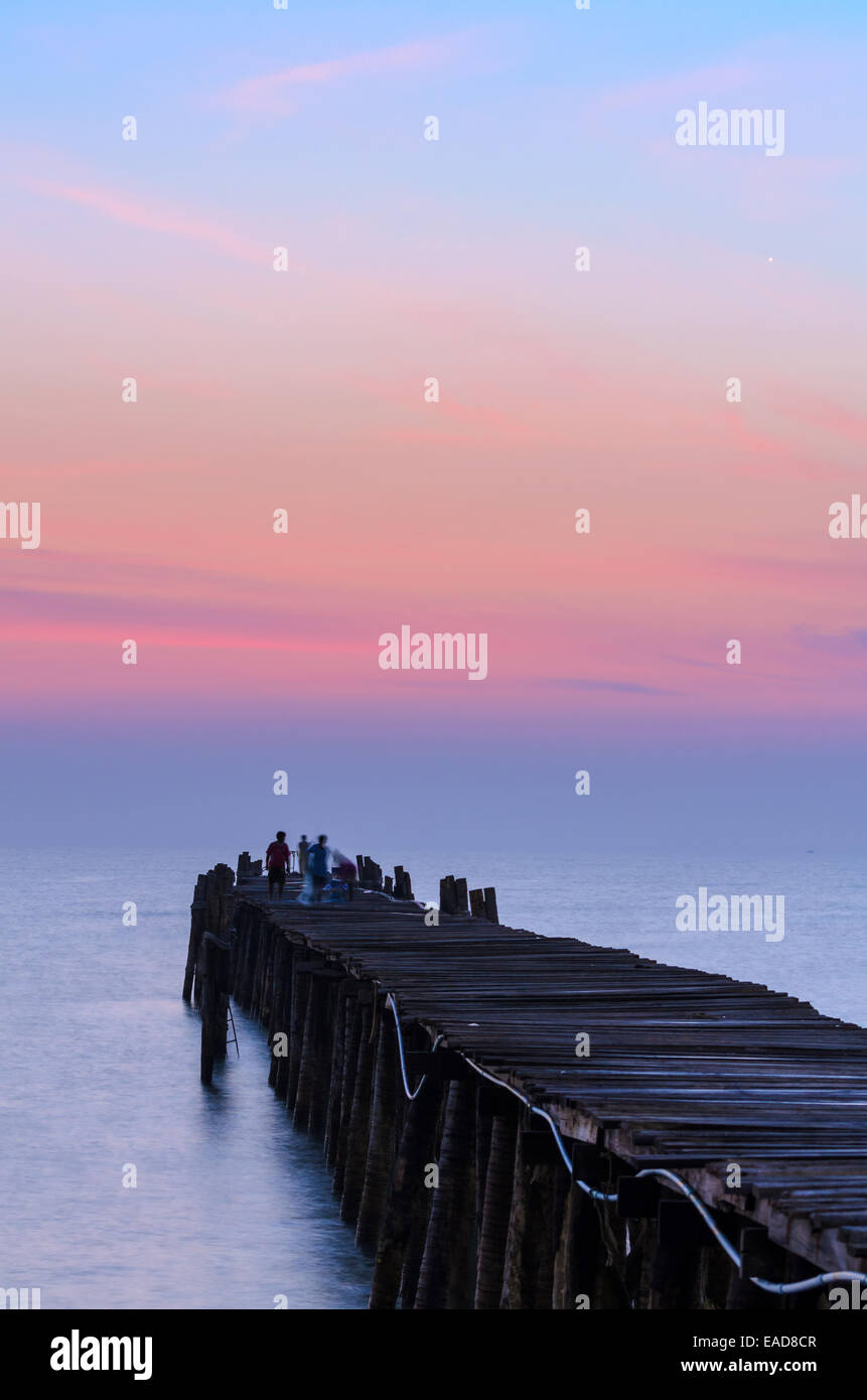 Silhouette Fischer auf die alte Holzbrücke und das Meer bei Sonnenaufgang im ländlichen Thailand. Stockfoto