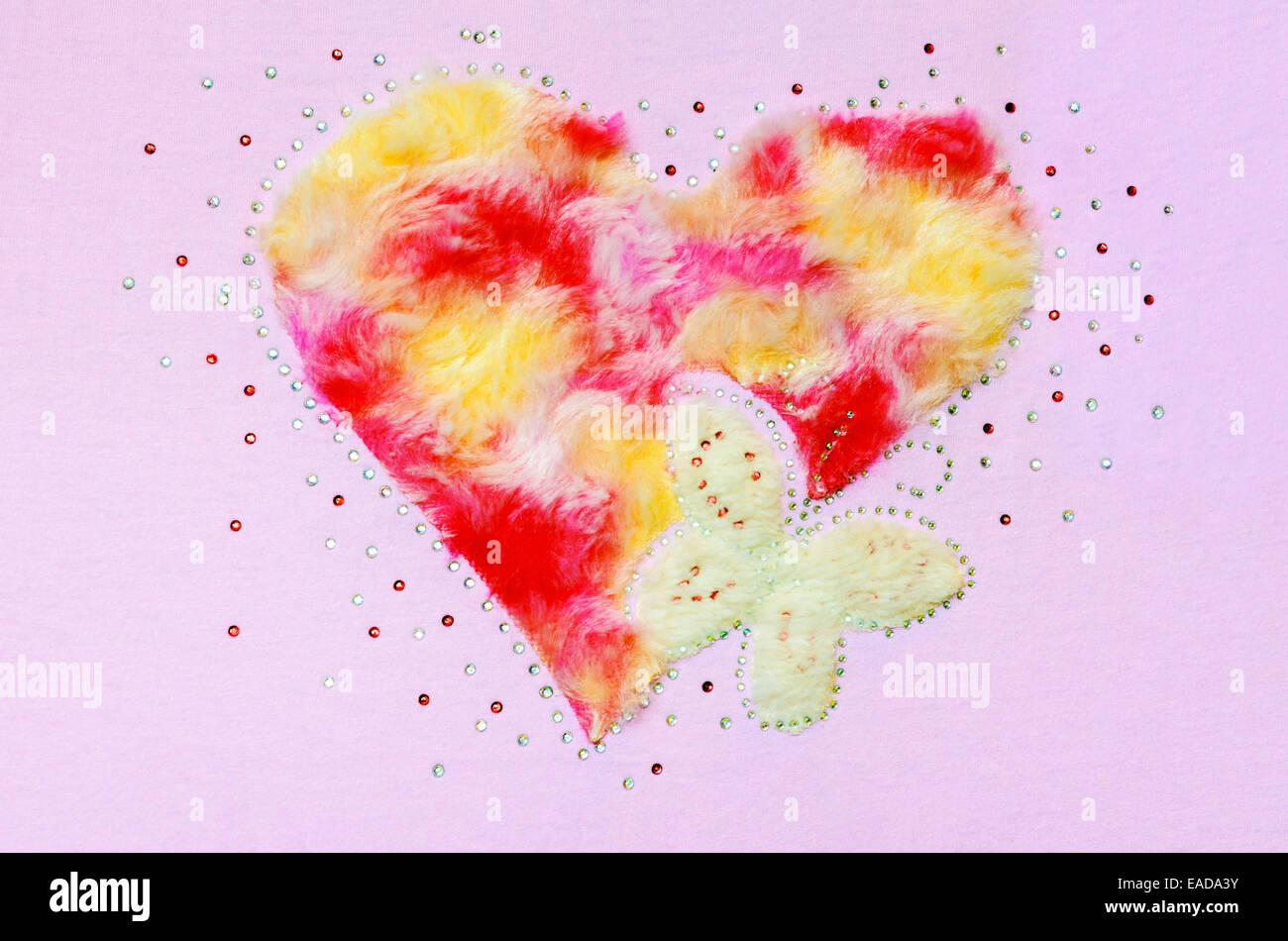 Herz Schmetterling Flusen und Pailletten, Dekoration auf einem rosa Stoff-Hintergrund Stockfoto