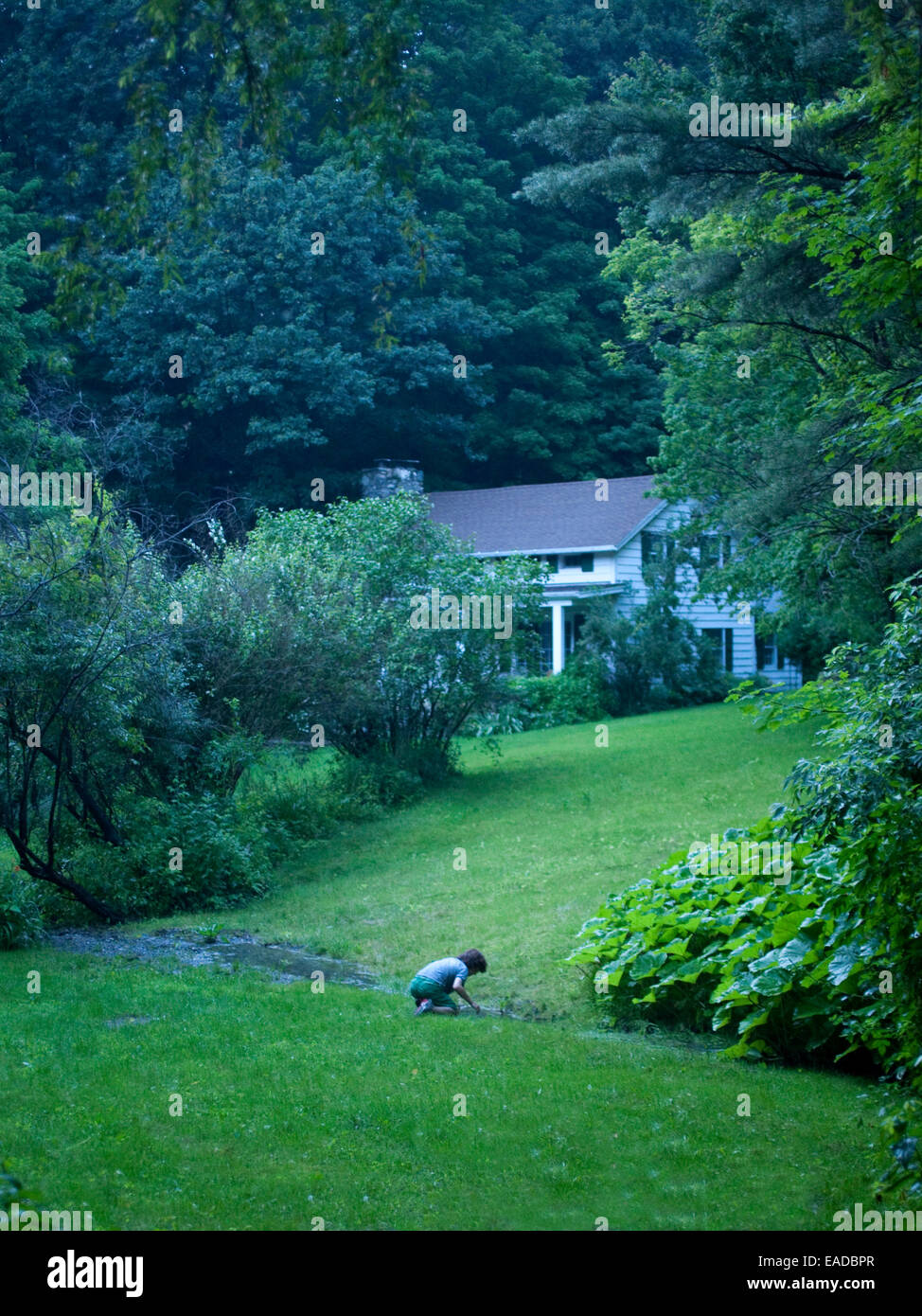 Junge spielt im Creek Country House Stockfoto