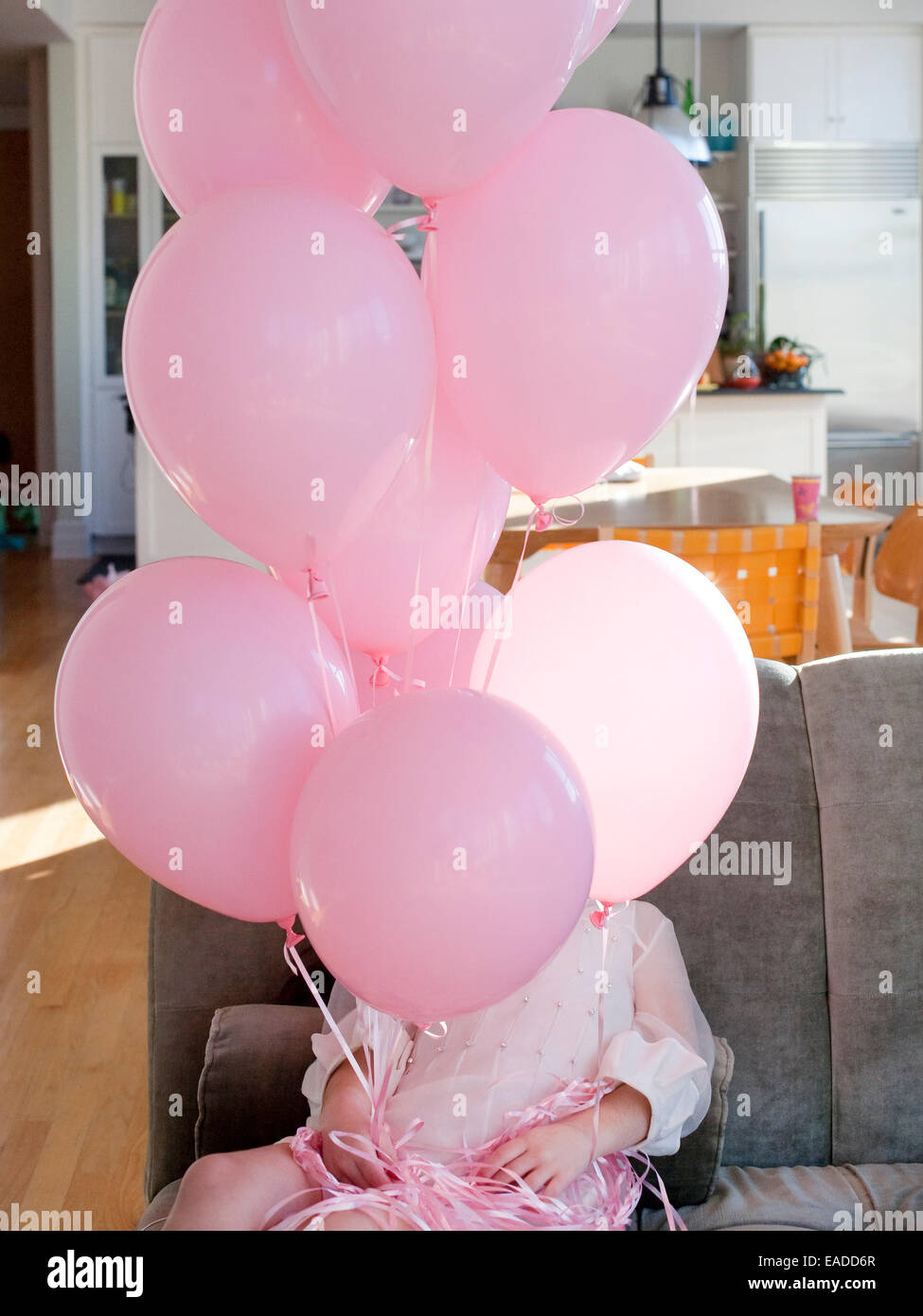 Mädchen im rosa Kleid mit rosa Ballons Stockfoto