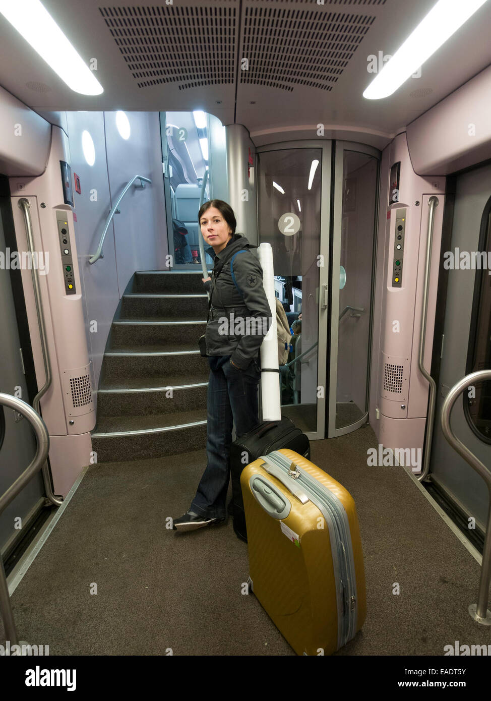 Junge Frau mit Koffer stehen im Zug Stockfoto