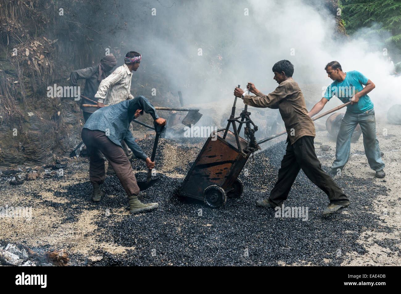 Arbeitnehmer Anwendung heißen Asphalt zu einer Straße auf einer Baustelle, Shimla, Himachal Pradesh, Indien Stockfoto