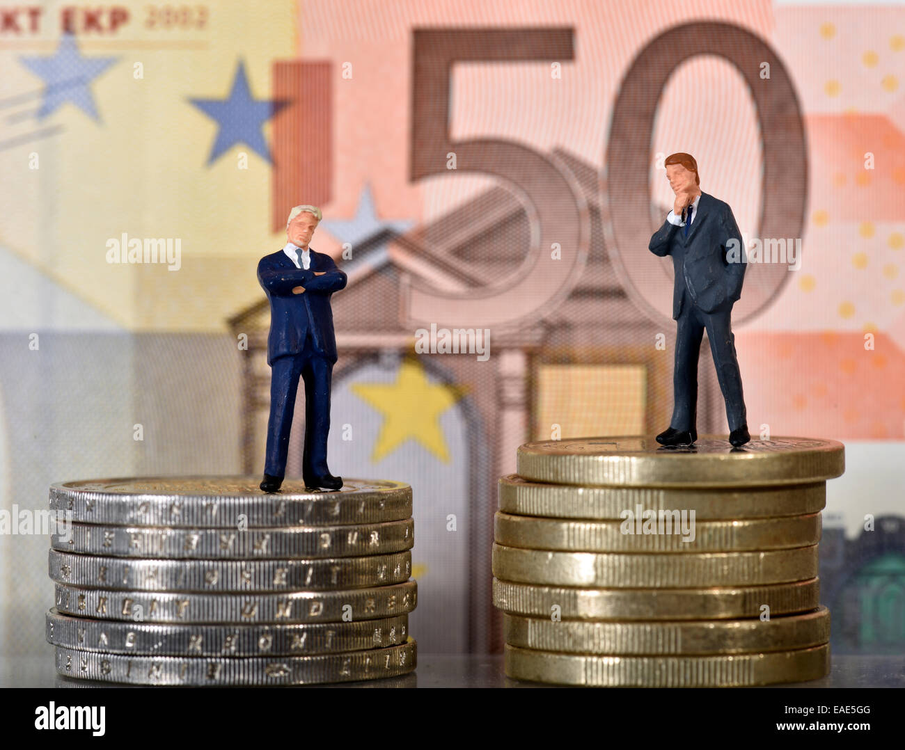 Symbolisches Bild für das Kapital, zwei Manager auf Münzen vor 50 Euro-banknote Stockfoto