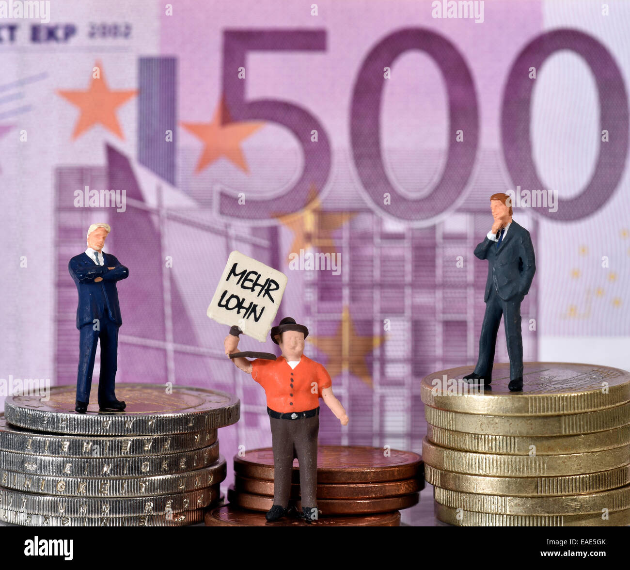Symbolisches Bild für das Kapital, zwei Manager und ein union Arbeiter auf Münzen vor 500 Euro-Schein Stockfoto