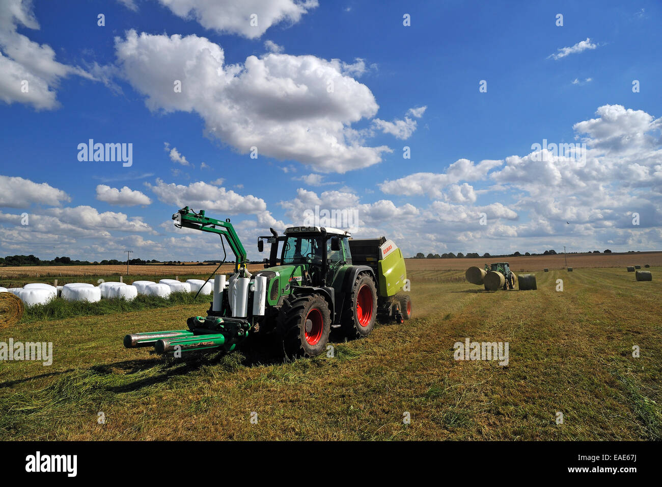 Heuernte, Traktoren auf einer Wiese die Runde Ballen Silage, Groß Rünz, Mecklenburg-Western Pomerania, Deutschland Stockfoto