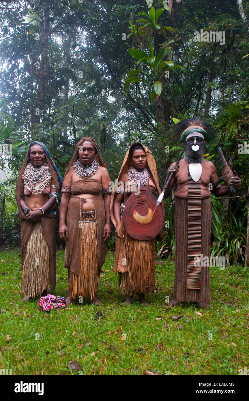 Stammesführer und drei Frauen tragen traditionelle Kleider, Highlands Region, Papua New Guinea Stockfoto