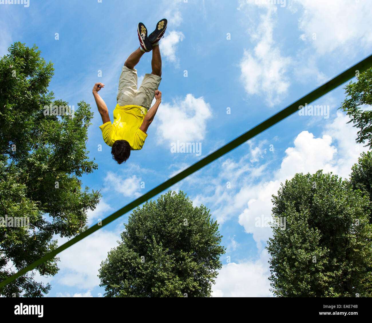 Junger Mann springt auf einer Slackline, Waiblingen, Baden-Württemberg, Deutschland Stockfoto
