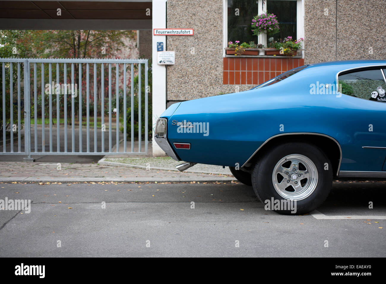 Blaue Vintage Buick Skylark in Berliner Straße geparkt mit modernen Beton und Backstein-Block von Wohnungen und Geländer Stockfoto