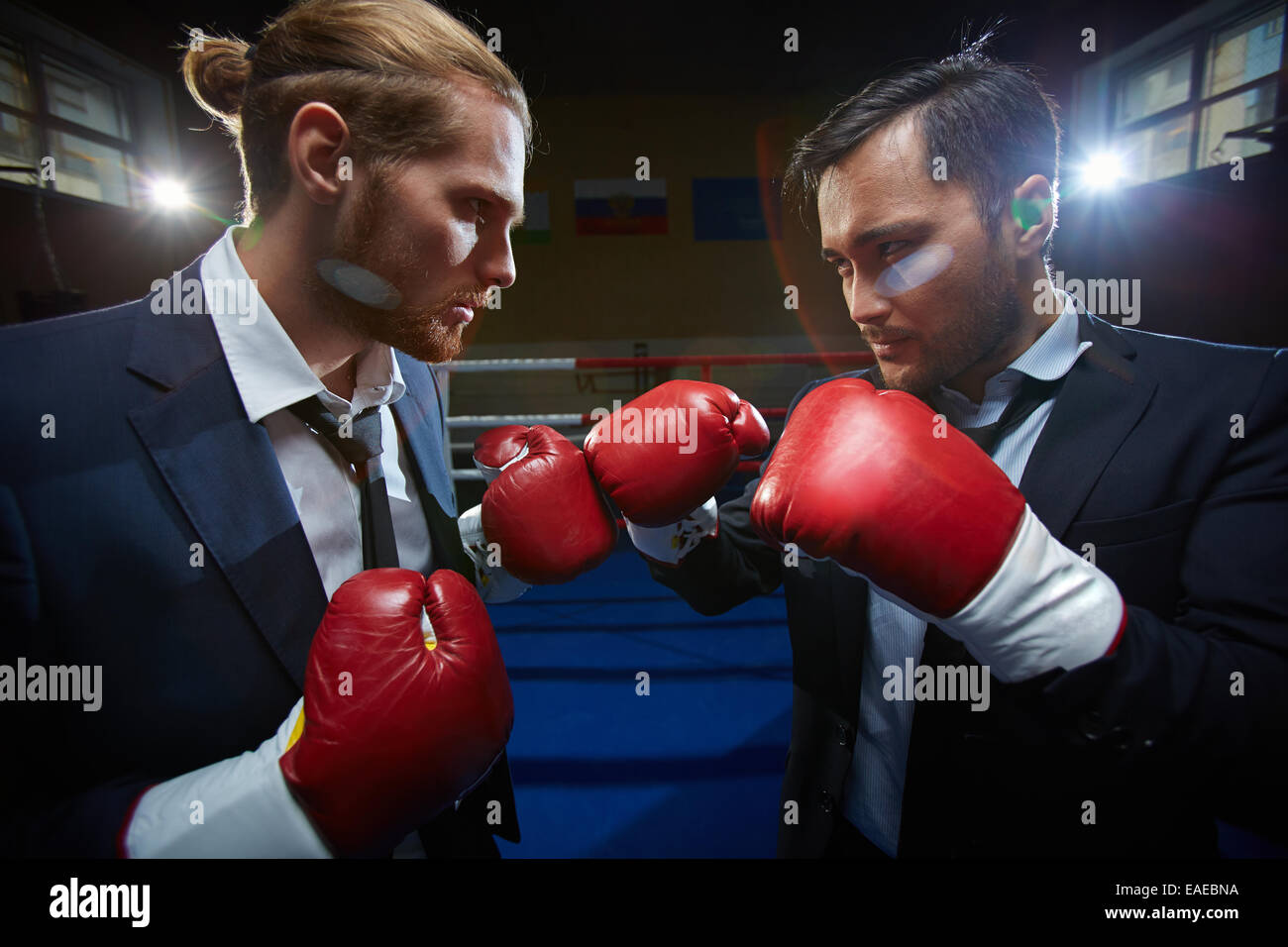 Böse Männer in Anzügen und Boxhandschuhe einander angreifen Stockfoto