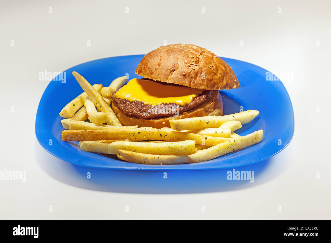 Blaue Platte mit einfachen Hamburger mit Scheibe Käse und Pommes Frites. Stockfoto