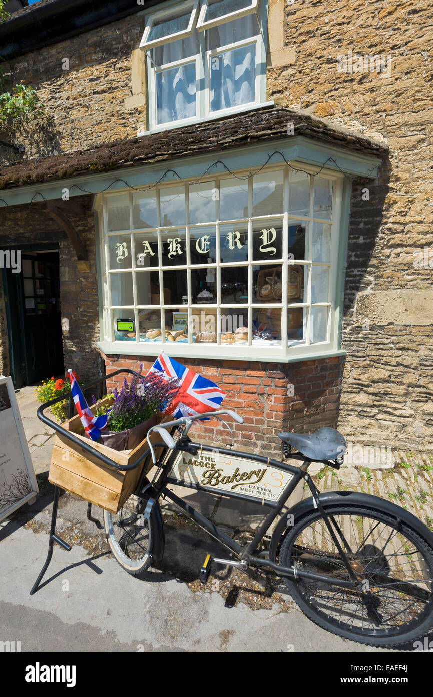 Avebury Dorfbäckerei und Shop mit alten altmodischen Fahrrad außerhalb. Korb-Fahrradtasche mit Lavendelblüten und Union Jack-Flaggen Stockfoto