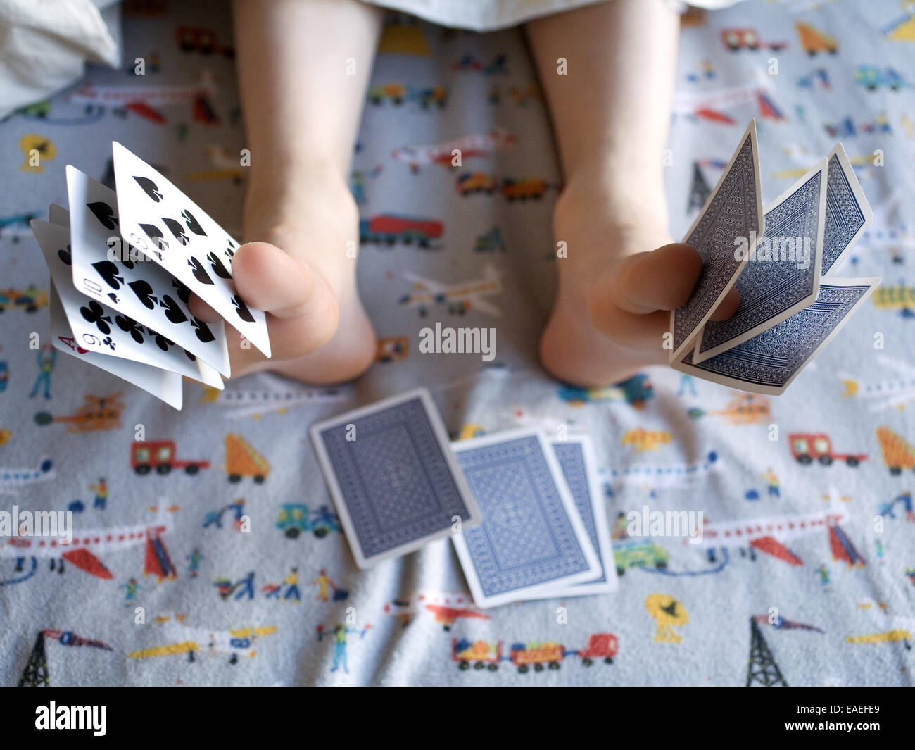 Kind mit Spielkarten zwischen ihre Zehen schlafen Stockfoto