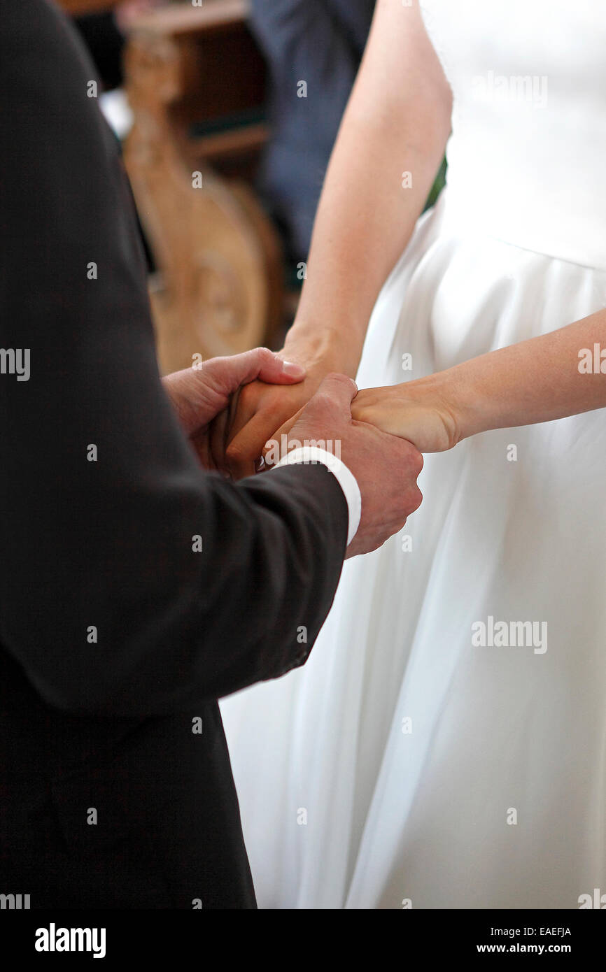 Hände der Braut und Bräutigam in der Kirche Stockfoto