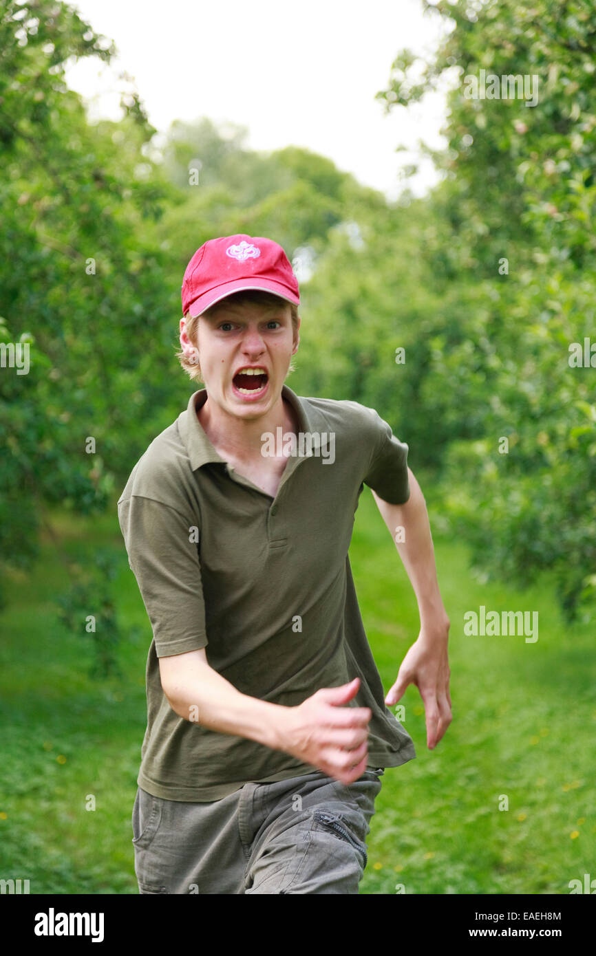 Teenager junge 15 Jahre alt läuft im Apfelgarten Stockfotografie Alamy