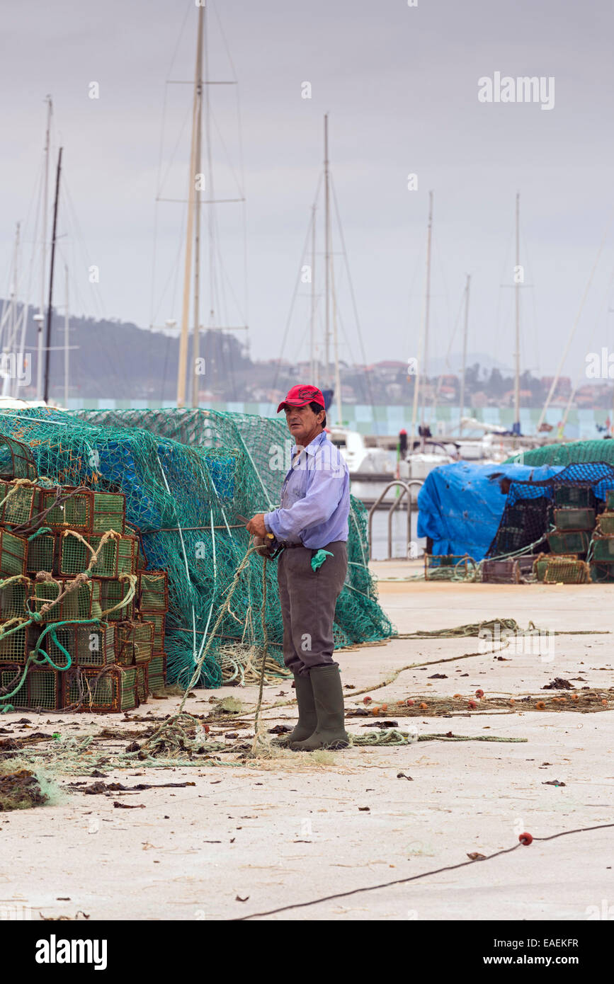 BAIONA, Spanien - 3. September 2014: Ein unbekannter Fischer repariert Fischernetze im Hafen Stockfoto