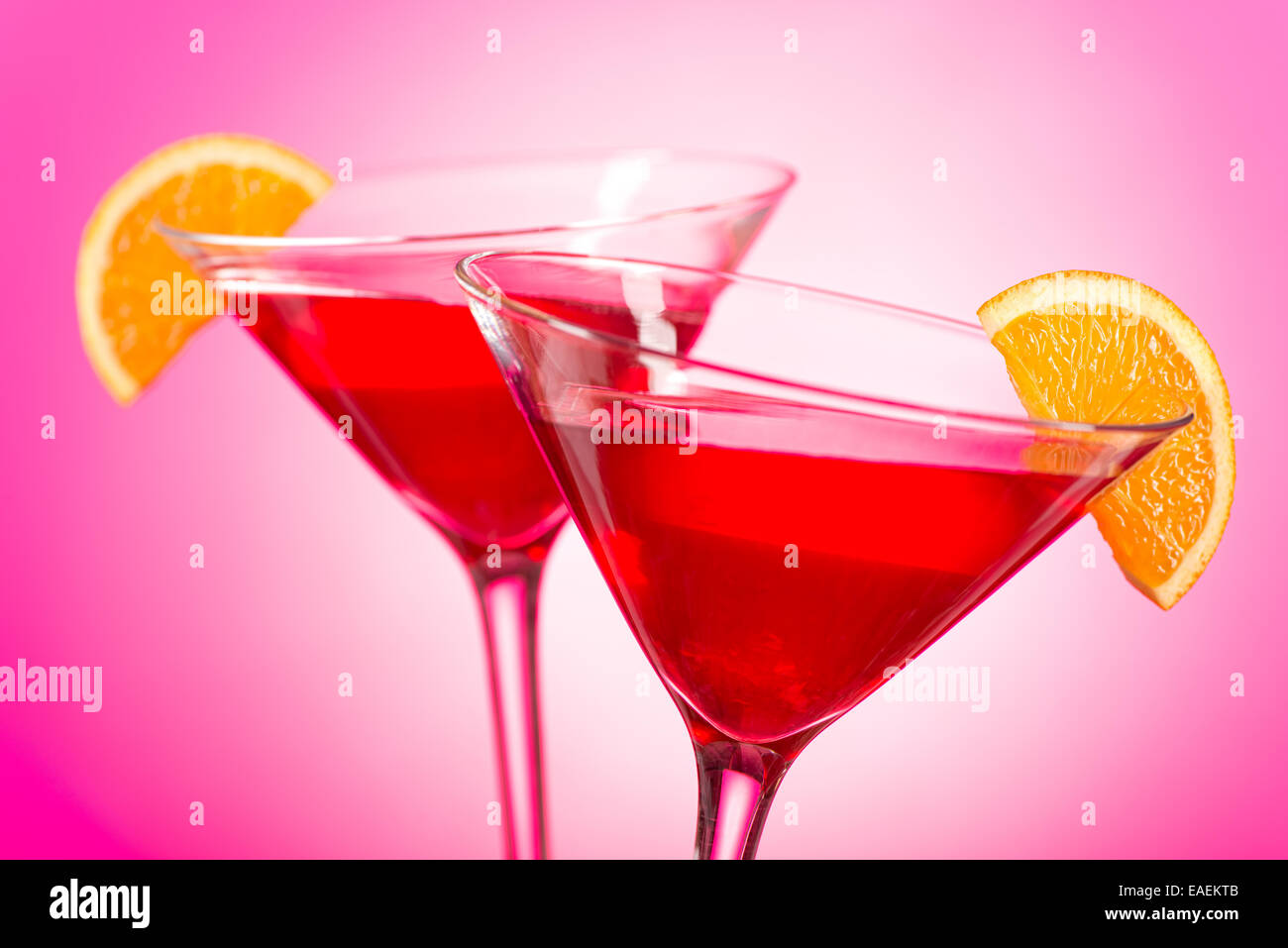 Zwei leckere cosmopolitan Cocktails mit Cranberry-Saft, Wodka, triple sec und frisch gepressten Limettensaft mit einer orange garni Stockfoto