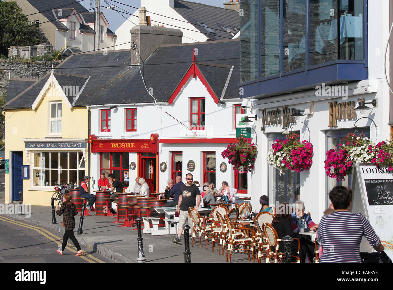 Außerhalb Irlands. An einem sonnigen Tag in Baltimore County Cork sitzen Menschen vor Pubs und Restaurants in Irland in einem Pub an der Küste. Stockfoto