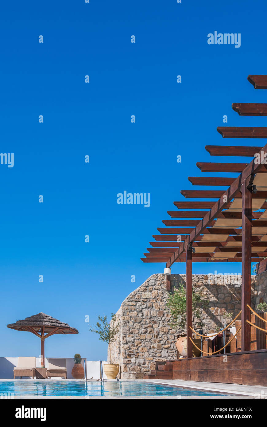 Ein Blick über einen Infinity-Pool in einem mediterranen Stil Luxus Hotel Resort, umrahmt von einem klaren blauen Himmel. Stockfoto