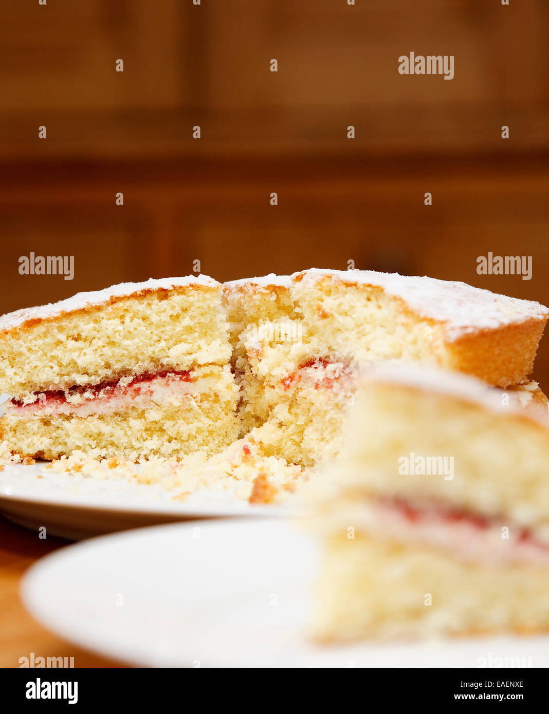 traditionelle Victoria Biskuit mit Buttercreme und Marmelade füllen in einer rustikalen Umgebung zu Hause Stockfoto