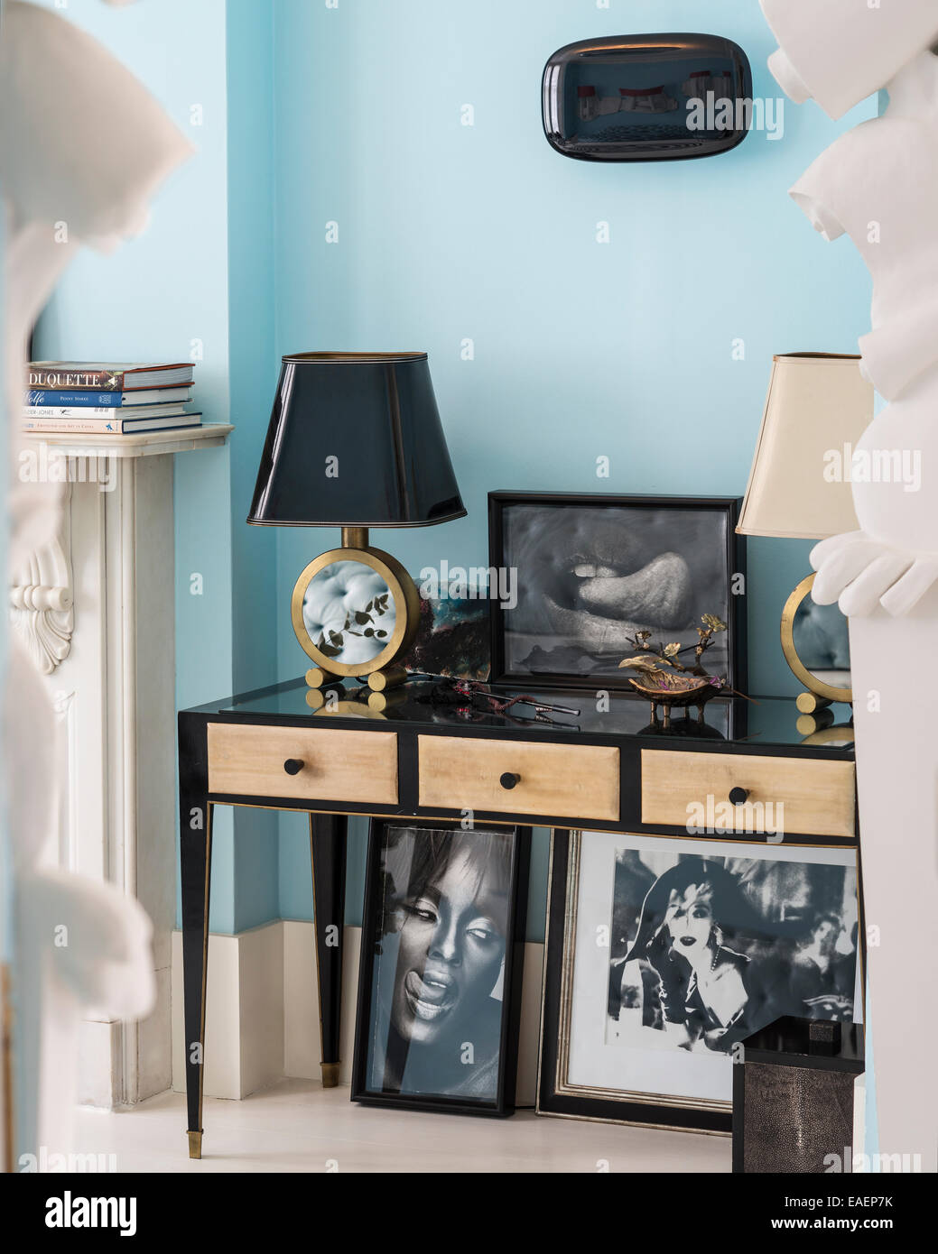 Paar gespiegelte Lampe steht und Kunstwerk auf Tisch mit schwarz / weiß Fotografie unter Stockfoto