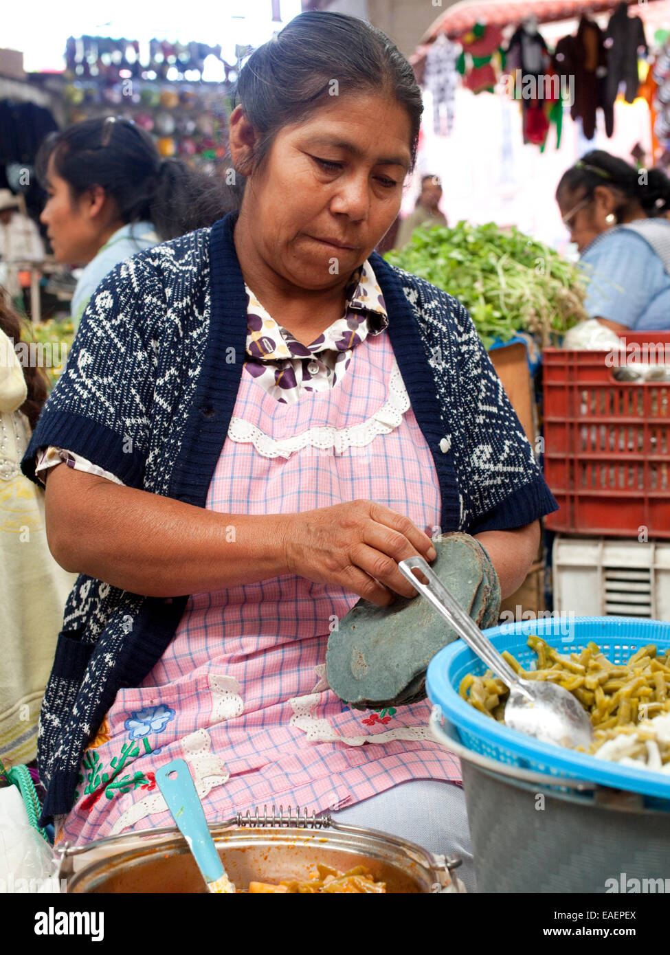 Eine Frau peeling auseinander blauem Mais Tortillas auf einem Markt in Mexiko Stockfoto