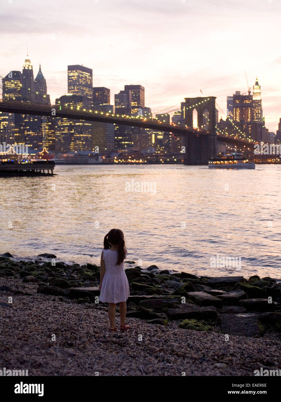 Junge Mädchen schaut auf Manhattan in der Dämmerung Stockfoto