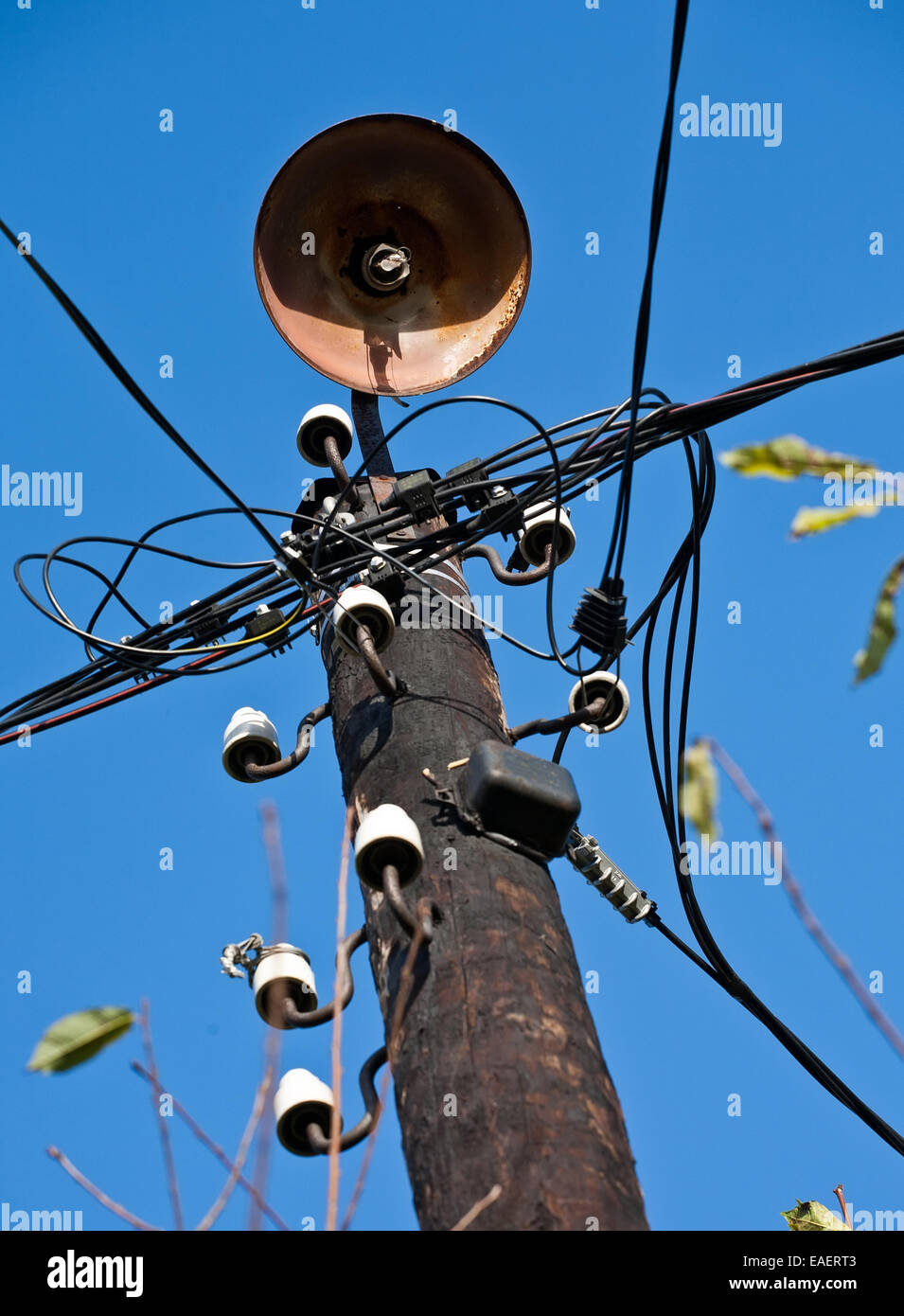 hölzerne Telegrafenmast mit alten Straßenlaterne Closeup auf blauen Himmelshintergrund Stockfoto