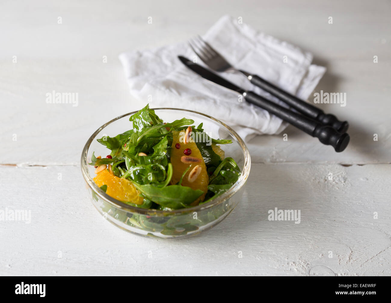 Rucola-Salat mit Früchten und Besteck Stockfoto