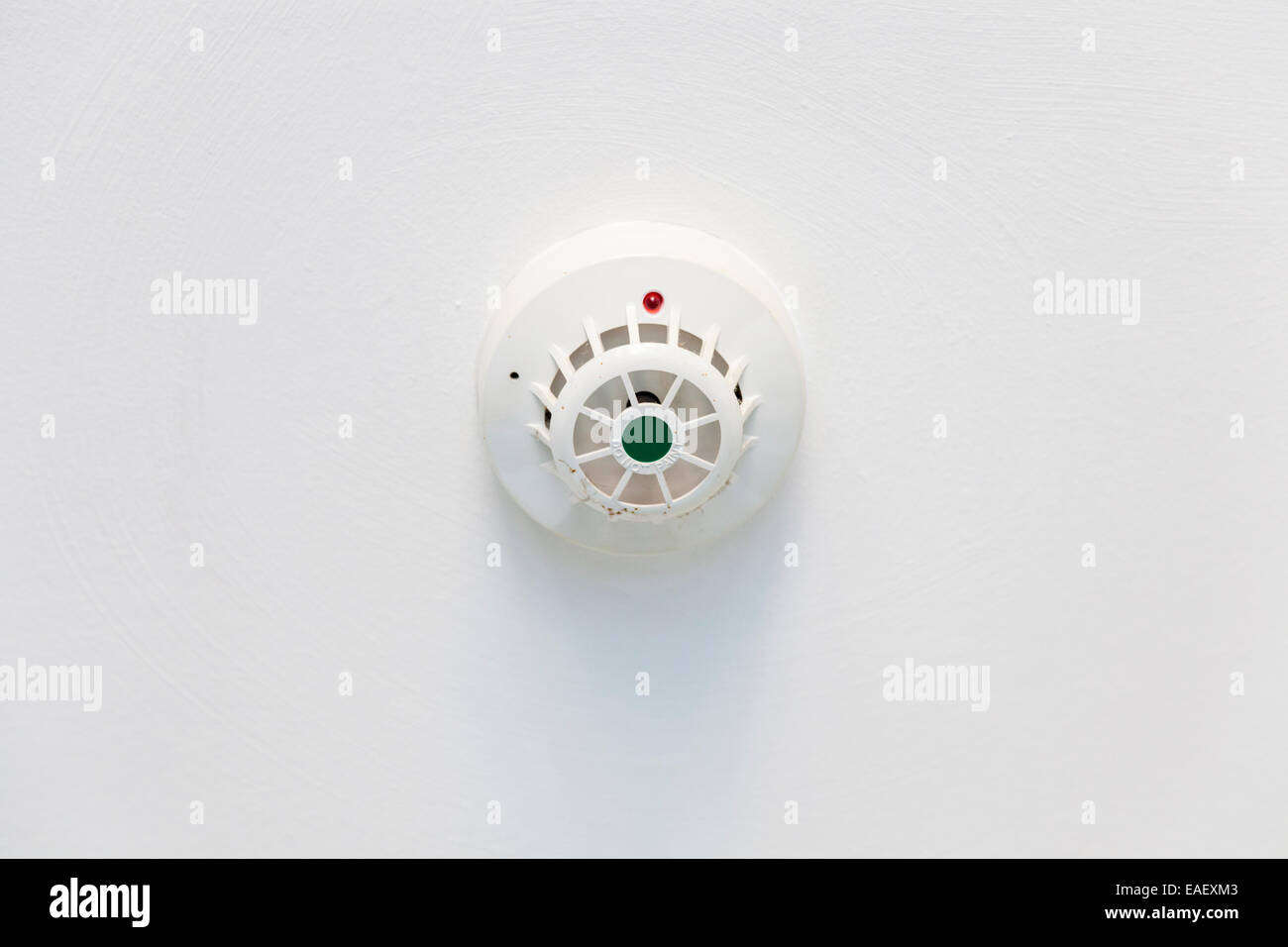 An der Decke montierte weiß Rauchmelder als Teil einer Brandmeldeanlage in Großbritannien Stockfoto