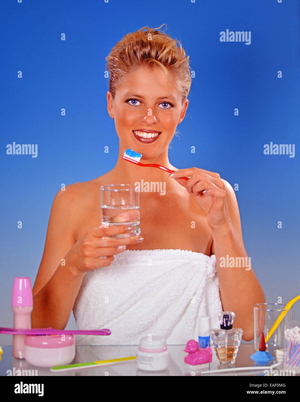 Blonde Frau, die seine Zähne putzen Stockfoto