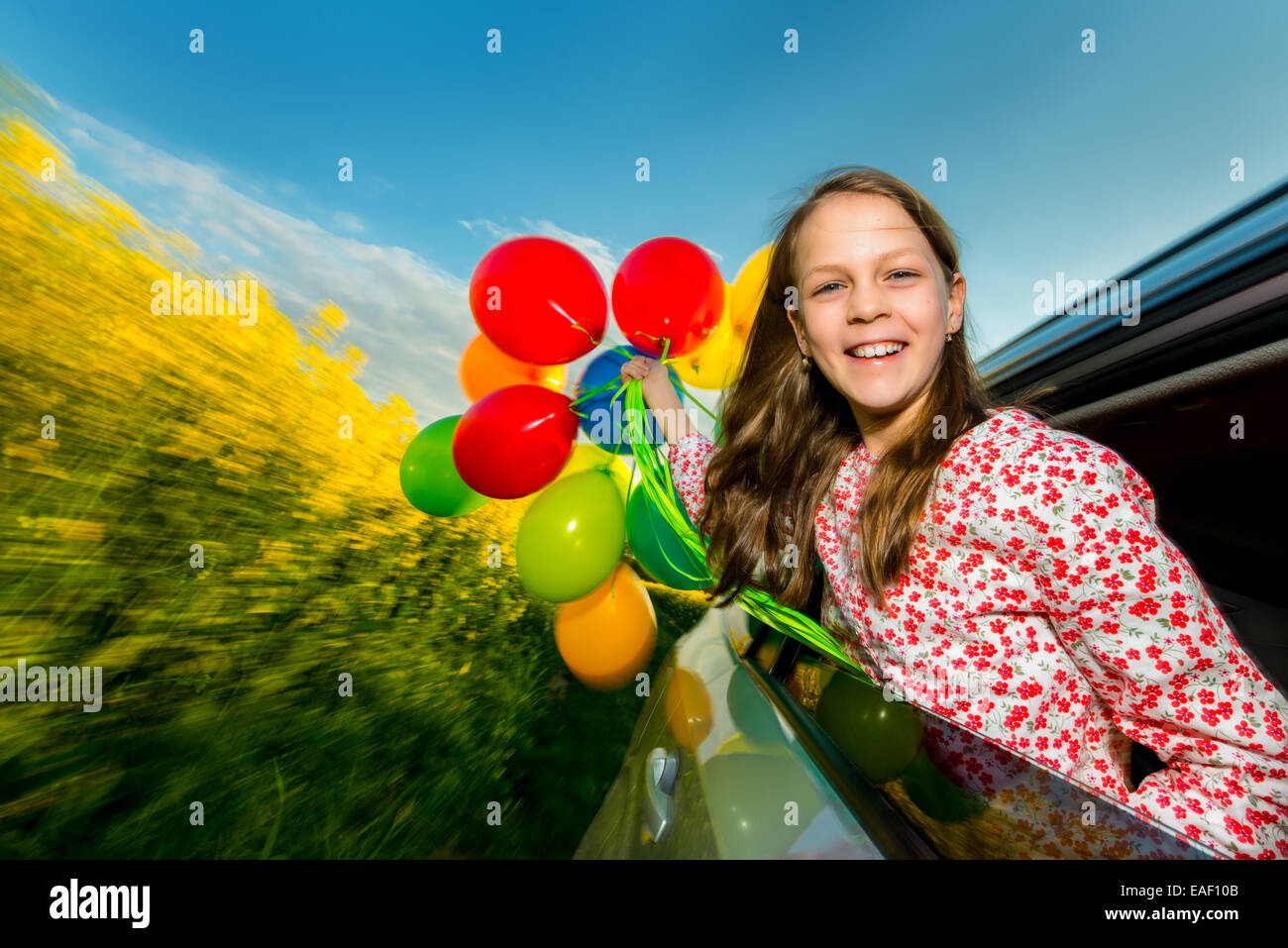 Kleines Mädchen mit Luftballons lachen Stockfoto