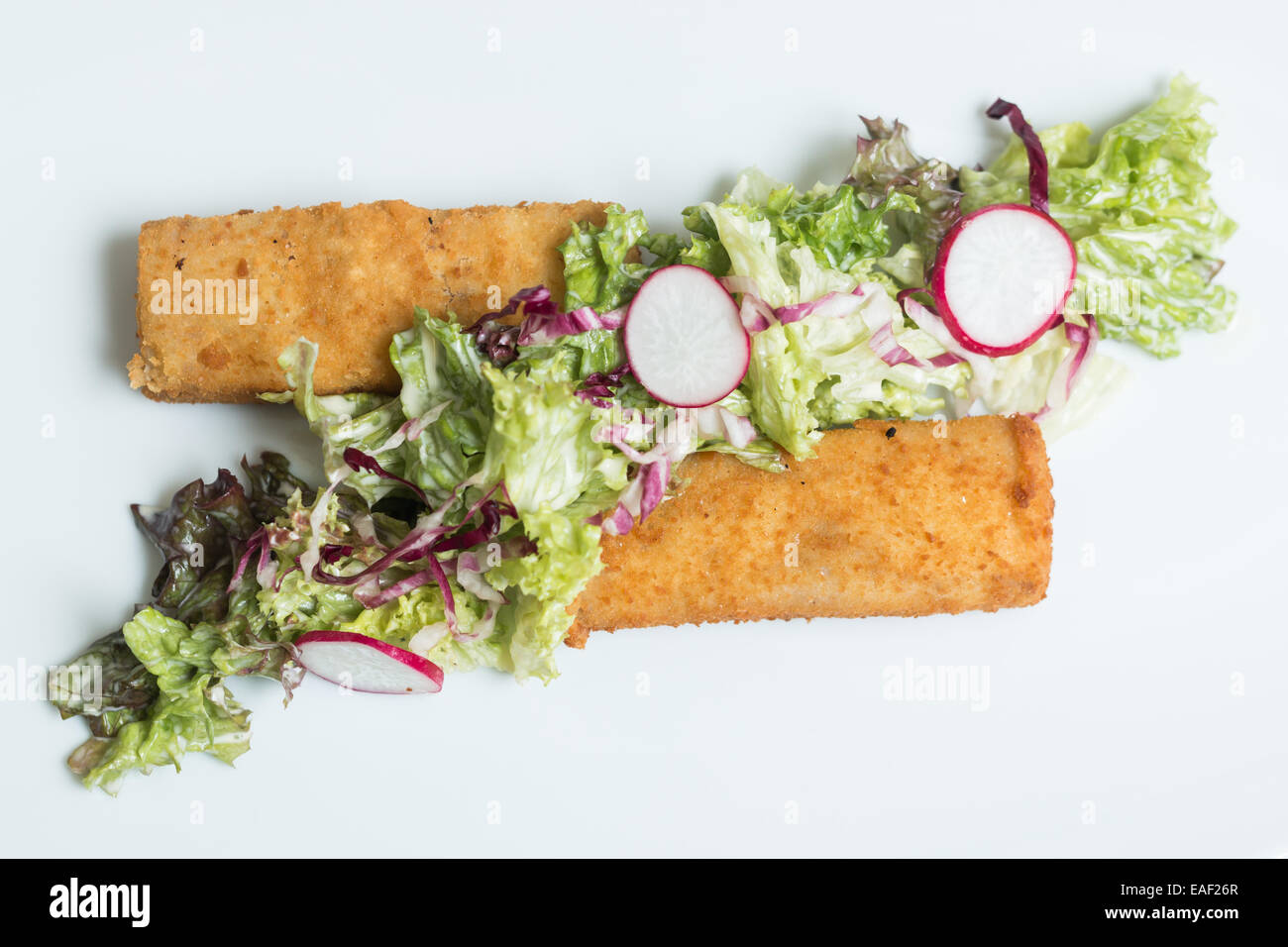 Fischstäbchen mit grünem Salat garniert mit Radieschen Stockfoto