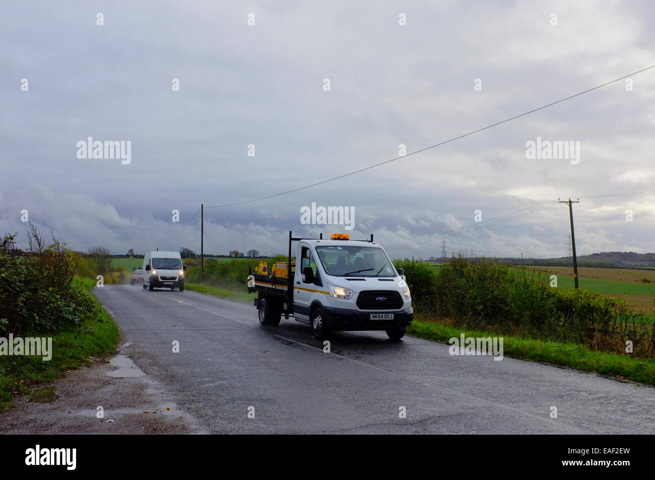 Handwerker-Fahrzeuge auf einen nassen Feldweg in Bedfordshire Stockfoto