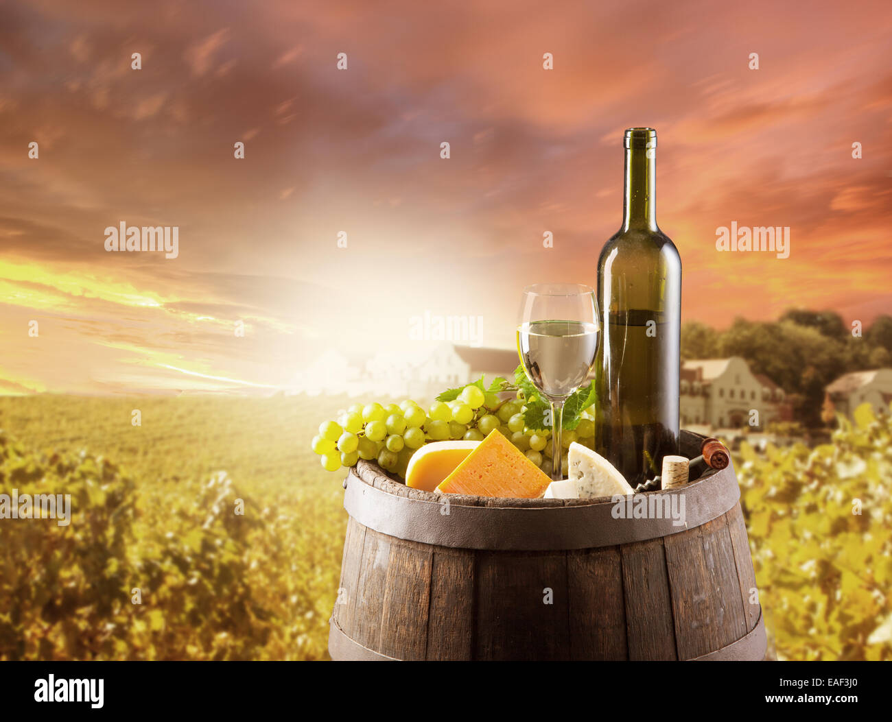 Alte hölzerne Fass mit Flasche und Glas Weißwein. Ländlichen Weinberg im Hintergrund Stockfoto