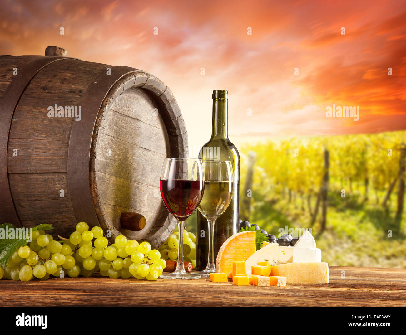 Alte hölzerne Fass mit Flasche und Glas Rotwein, Weißwein. Ländlichen Weinberg im Hintergrund Stockfoto
