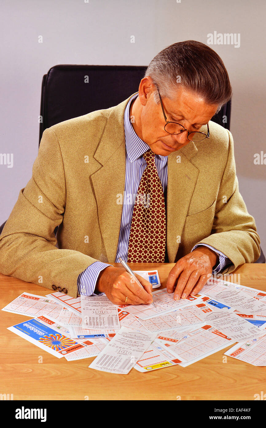 Senior, verschiedene Lottoscheine ausfüllen Stockfoto