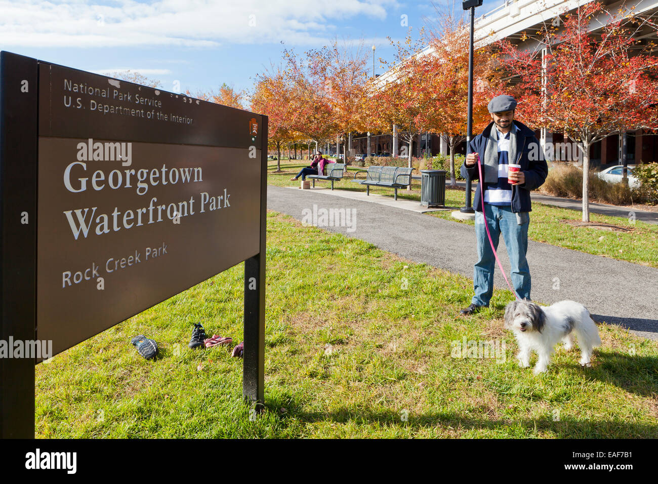 Mann zu Fuß Hund an Georgetown Waterfront Park - Washington, DC USA Stockfoto