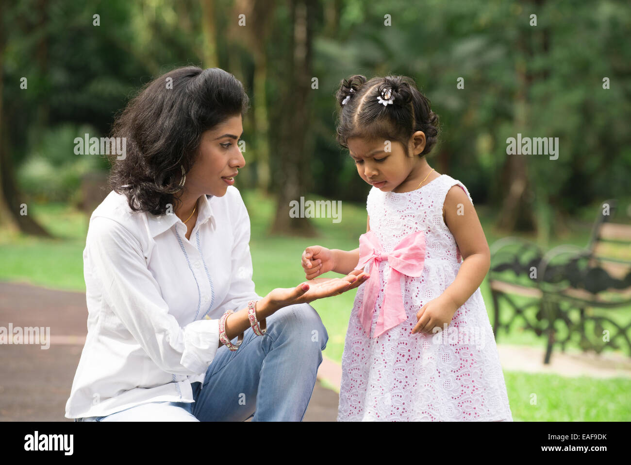 Glückliche indische Mutter und Tochter spielen im Park. Lifestyle-Bild. Stockfoto